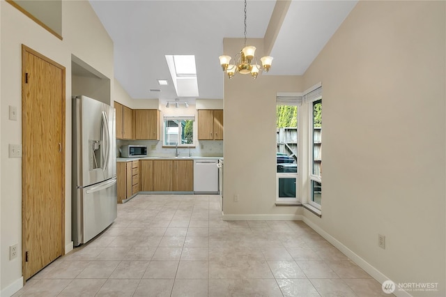 1004 30th St NE, Auburn, WA 98002 - kitchen featuring appliances with stainless steel finishes, light countertops, a chandelier, baseboards, and decorative light fixtures