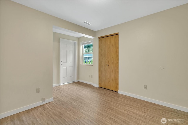 1004 30th St NE, Auburn, WA 98002 - unfurnished bedroom with light wood-style flooring, baseboards, and a closet