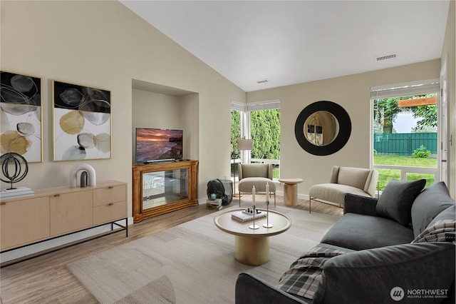 1004 30th St NE, Auburn, WA 98002 - living room featuring wood finished floors, lofted ceiling, healthy amount of natural light, and baseboards
