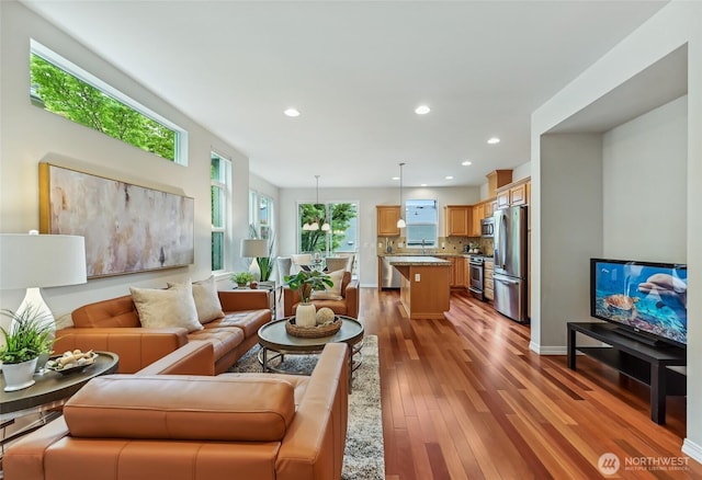living area featuring wood finished floors, recessed lighting, and baseboards