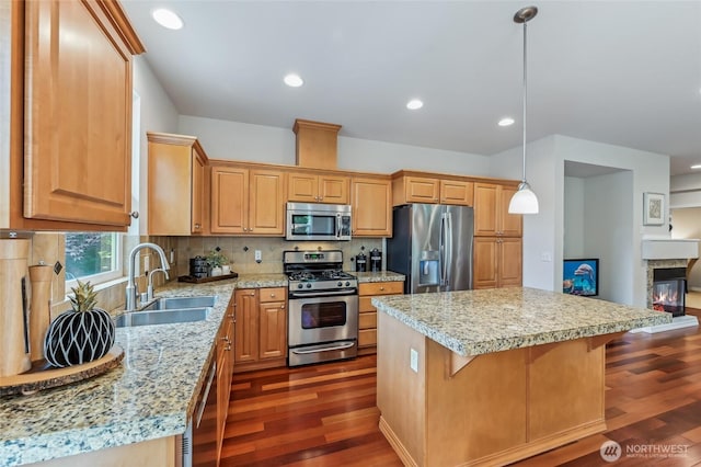 kitchen with stainless steel appliances, a sink, dark wood finished floors, a center island, and recessed lighting