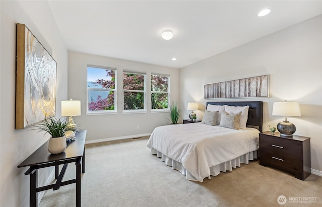 bedroom with light colored carpet, baseboards, and recessed lighting