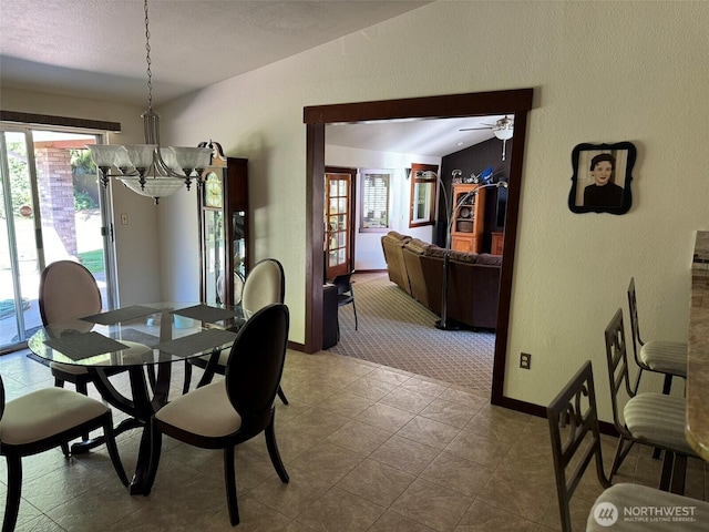 dining room featuring a textured wall, plenty of natural light, baseboards, carpet flooring, and a ceiling fan