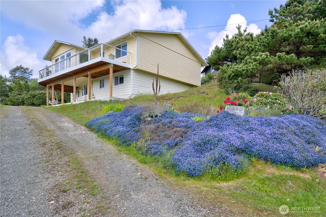 1005 346th Pl, Ocean Park, WA 98640 - view of front of house with a wooden deck and dirt driveway