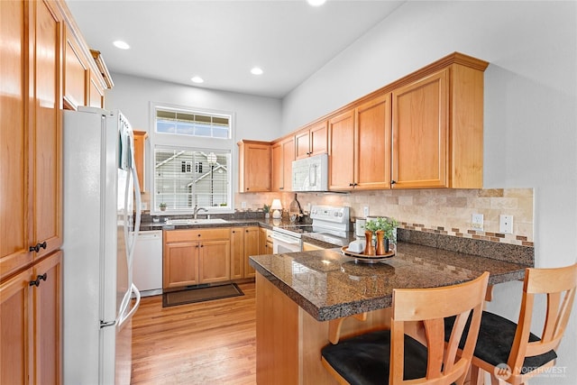 1725 Harrison Pl Unit 103, Lynden, WA 98264 - kitchen featuring white appliances, a peninsula, dark countertops, tasteful backsplash, and recessed lighting