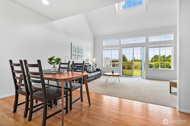 1725 Harrison Pl Unit 103, Lynden, WA 98264 - dining room featuring high vaulted ceiling, baseboards, light colored carpet, and light wood-style flooring
