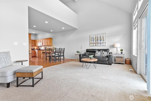 1725 Harrison Pl Unit 103, Lynden, WA 98264 - living room with light carpet, recessed lighting, high vaulted ceiling, and light wood-type flooring