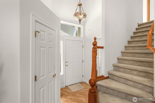entryway featuring stairs, light wood-type flooring, and baseboards