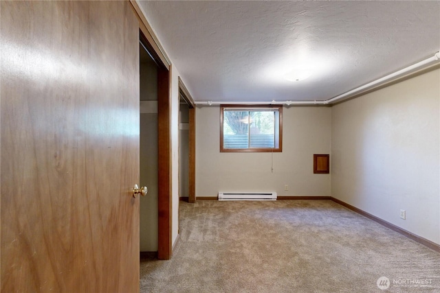 carpeted spare room with a textured ceiling, baseboards, and baseboard heating