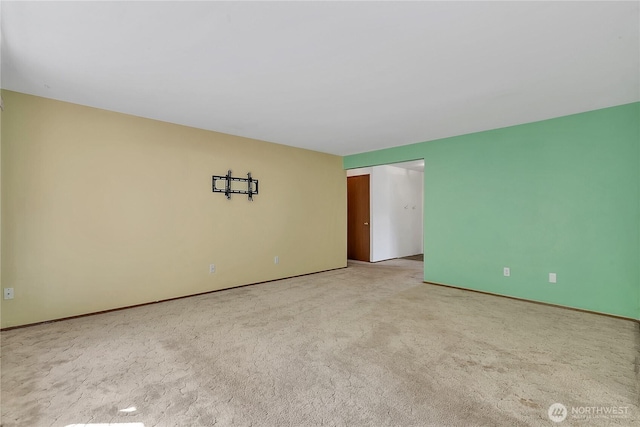 spare room with light colored carpet and baseboards