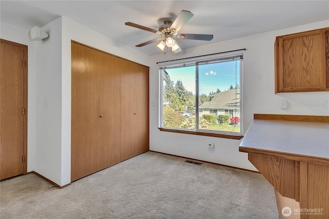 unfurnished bedroom with light carpet, a closet, baseboards, and a ceiling fan