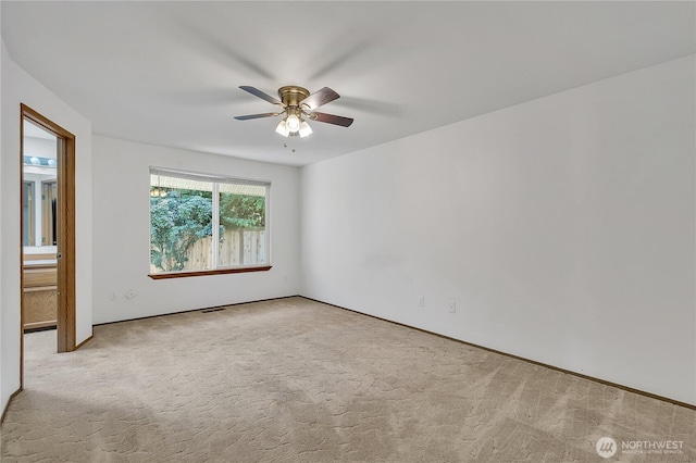 spare room featuring a ceiling fan, carpet floors, and baseboards