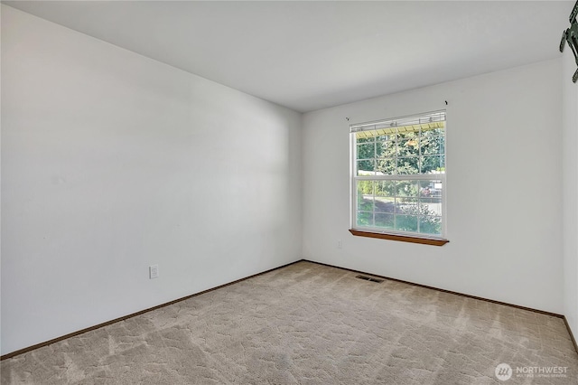 spare room with carpet and baseboards