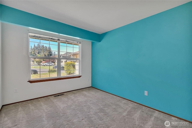 unfurnished room with carpet flooring and baseboards