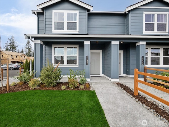 traditional home with covered porch and a front lawn