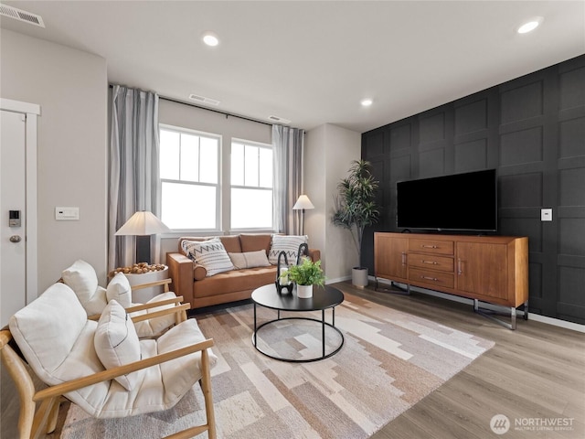 living area featuring light wood-style flooring, baseboards, visible vents, and recessed lighting