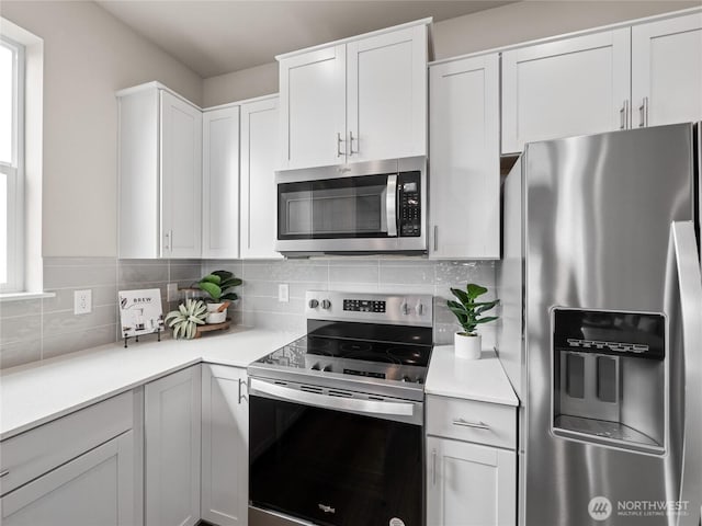 kitchen featuring white cabinets, light countertops, appliances with stainless steel finishes, and tasteful backsplash