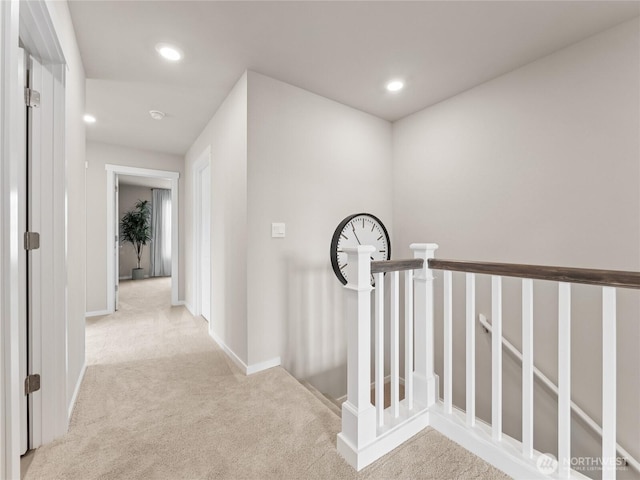 hall featuring baseboards, an upstairs landing, recessed lighting, and carpet