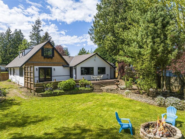 back of house with a fire pit and a wooden deck