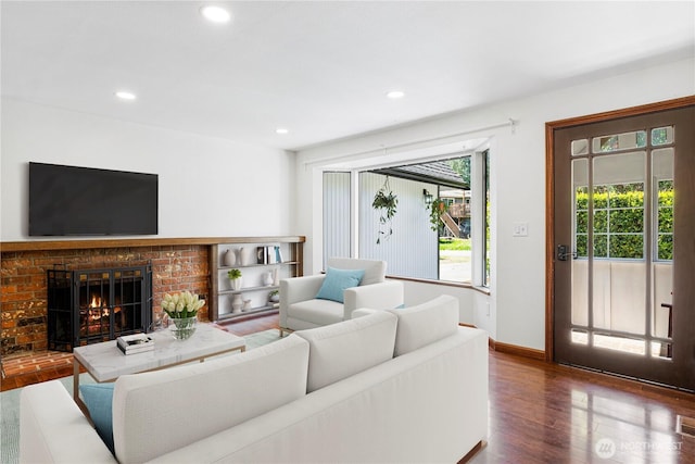living room featuring wood finished floors, recessed lighting, baseboards, and a fireplace