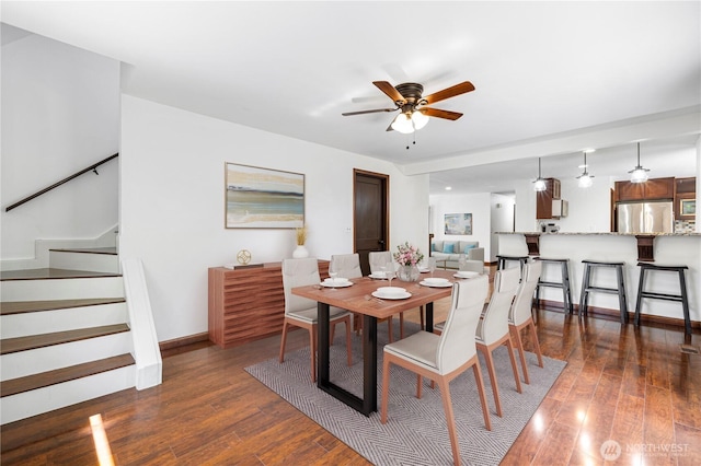 dining room featuring a ceiling fan, wood finished floors, stairway, and baseboards