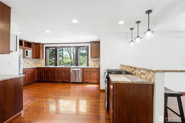 kitchen with appliances with stainless steel finishes, backsplash, dark wood-type flooring, and recessed lighting