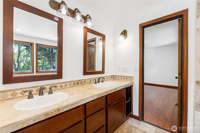 bathroom featuring double vanity and baseboards