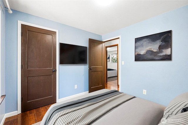 bedroom with wood finished floors and baseboards