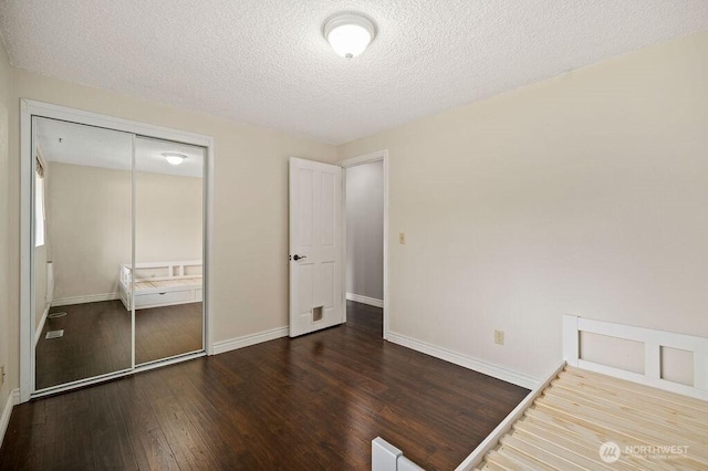 17919 3rd Ave NE, Arlington, WA 98223 - unfurnished bedroom featuring wood finished floors, baseboards, a closet, and a textured ceiling
