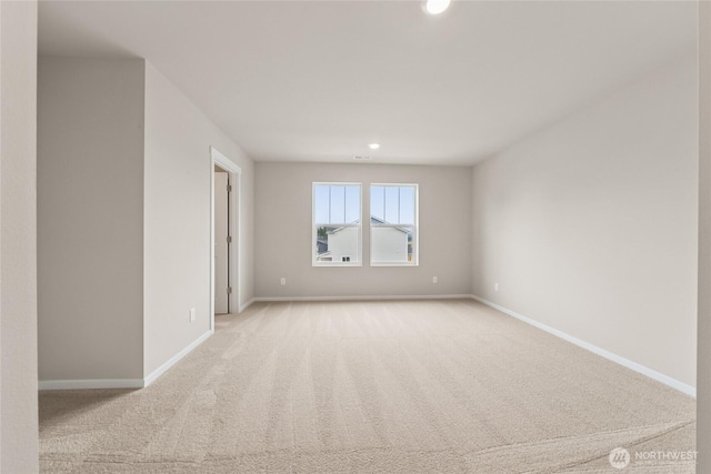 empty room featuring light carpet, baseboards, and recessed lighting
