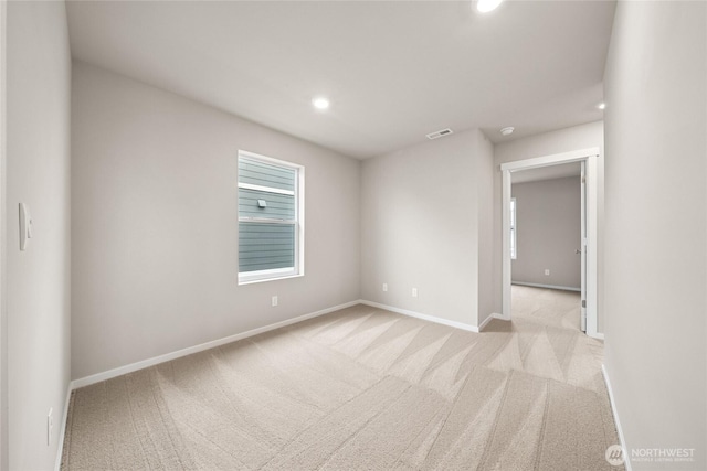 carpeted spare room featuring baseboards, recessed lighting, and visible vents