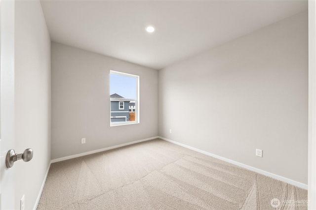carpeted empty room featuring baseboards