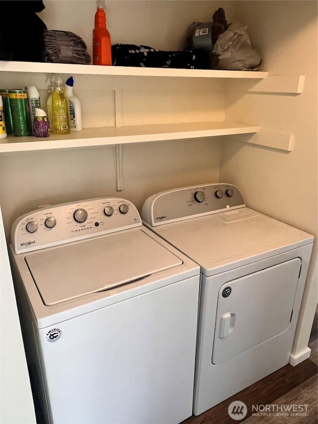 clothes washing area with washing machine and clothes dryer and wood finished floors