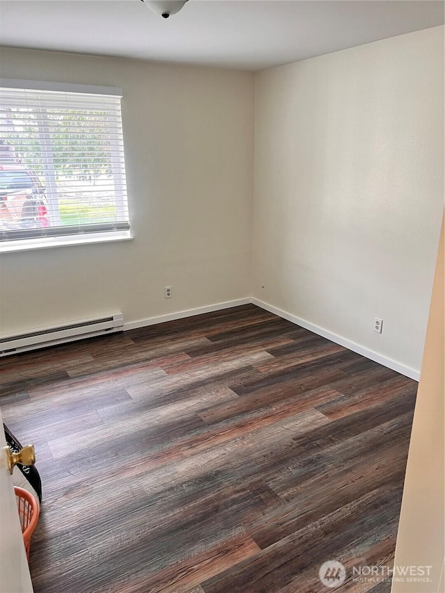 unfurnished room with baseboard heating, dark wood-type flooring, and baseboards