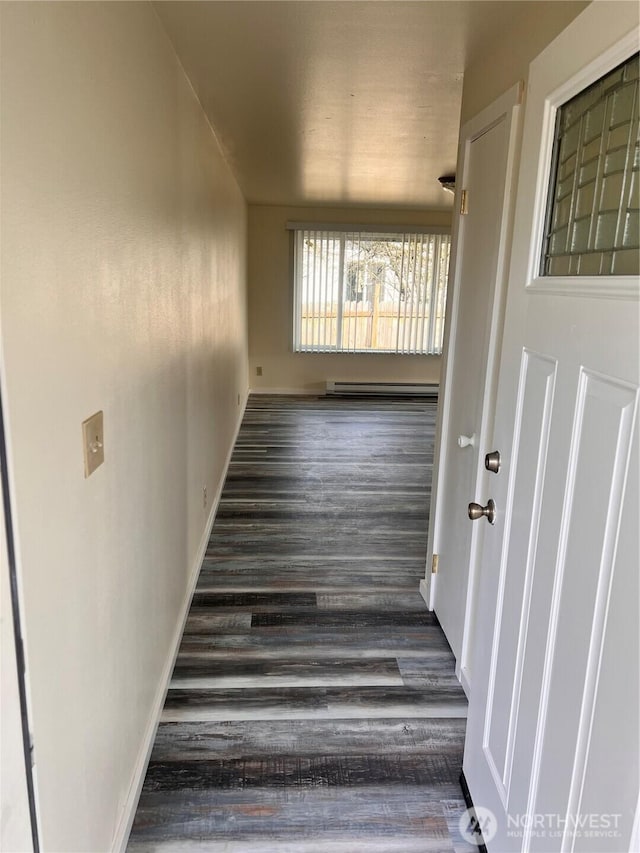 stairway with a baseboard radiator, wood finished floors, and baseboards