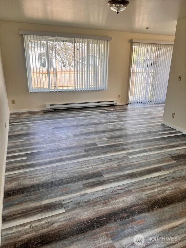 unfurnished living room with a baseboard radiator and wood finished floors
