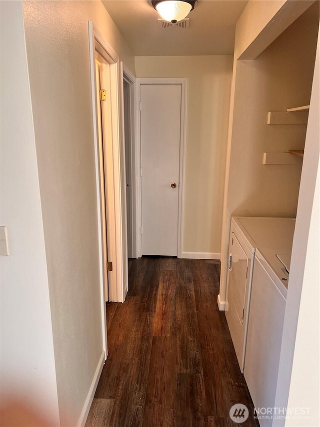 hall with washer and clothes dryer, dark wood-style floors, and baseboards