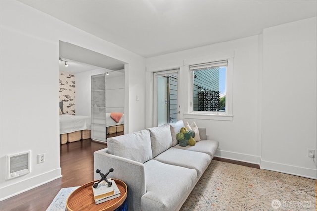 living room with baseboards, visible vents, and wood finished floors
