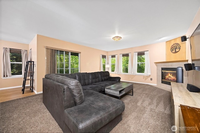 carpeted living room featuring healthy amount of natural light, baseboards, and a tile fireplace
