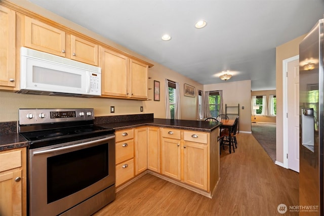 kitchen featuring appliances with stainless steel finishes, light brown cabinets, a peninsula, light wood-type flooring, and recessed lighting