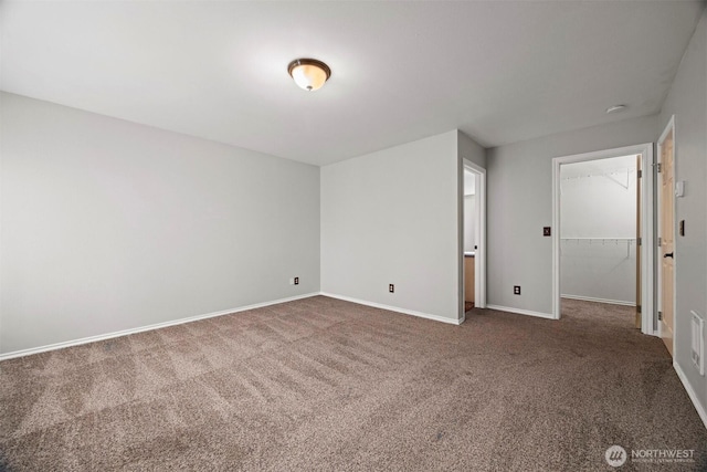 carpeted empty room featuring baseboards