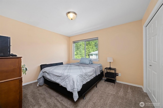 carpeted bedroom with a closet and baseboards