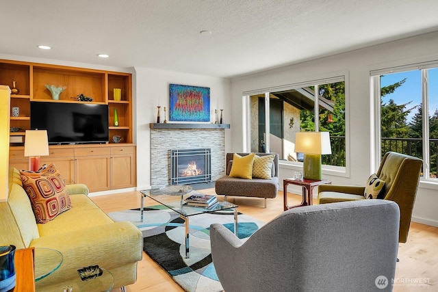 living area featuring light wood-style floors, a fireplace, and recessed lighting