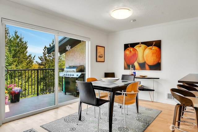 dining space featuring ornamental molding, visible vents, and wood finished floors