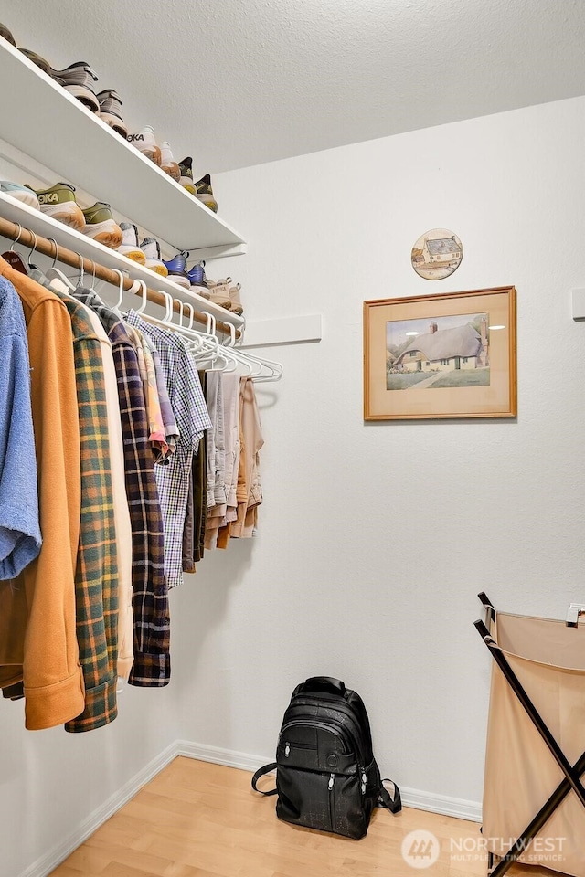 walk in closet with wood finished floors