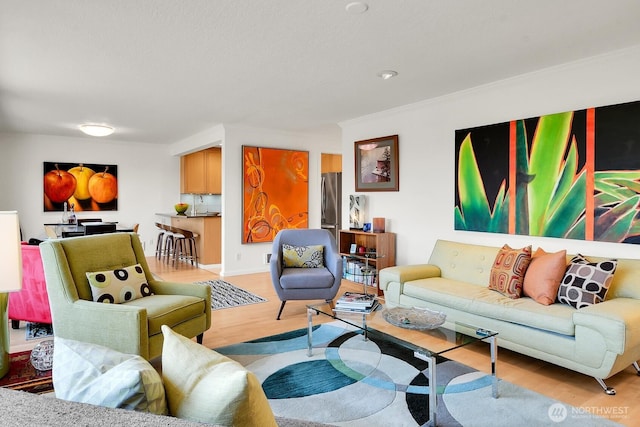 living area featuring light wood-style flooring and crown molding