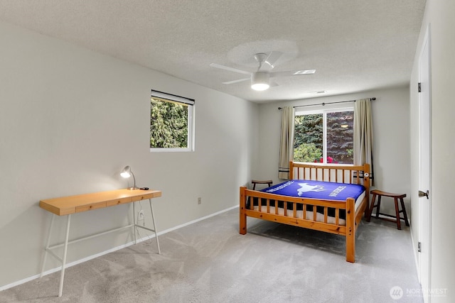 19801 88th Ave W, Edmonds, WA 98026 - carpeted bedroom featuring multiple windows, a textured ceiling, baseboards, and ceiling fan