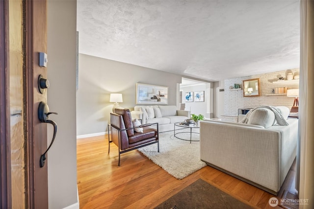 17922 Marine View Dr SW, Normandy Park, WA 98166 - living room with a textured ceiling, a brick fireplace, baseboards, and wood finished floors