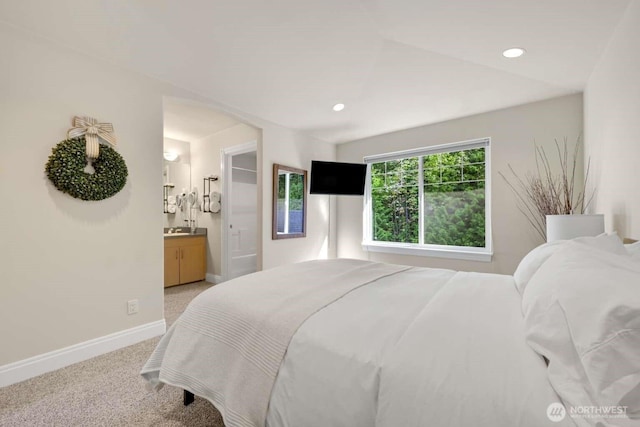 bedroom featuring baseboards, ensuite bath, recessed lighting, and light colored carpet