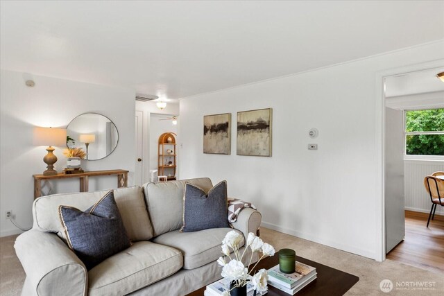 living area with light colored carpet and baseboards